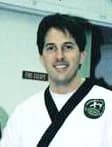 Steven White smiling in his martial arts uniform
